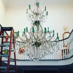 A chandelier with green lights hanging from the bottom.